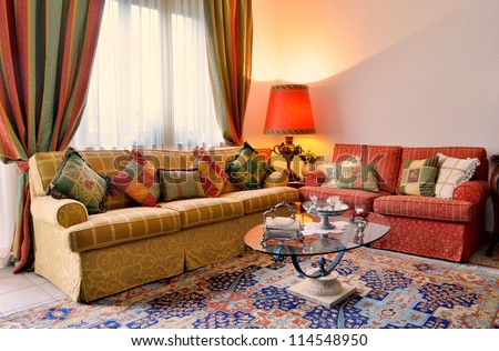 Elegant Living Room With Classic Looking Sofa, Colorful Curtains, Lamp And Glass Table