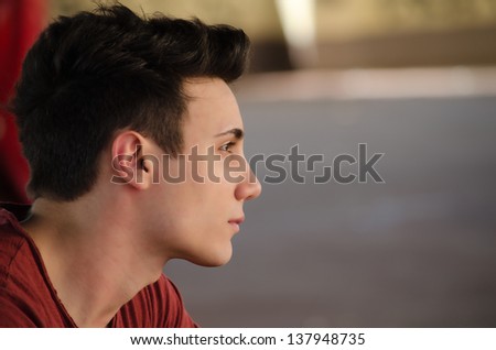 Attractive young man's side view portrait. Profile shot, outdoors