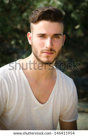 Portrait of attractive young man with white t-shirt, looking in camera