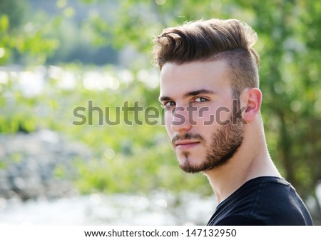 Portrait of attractive young man outdoors, looking in camera