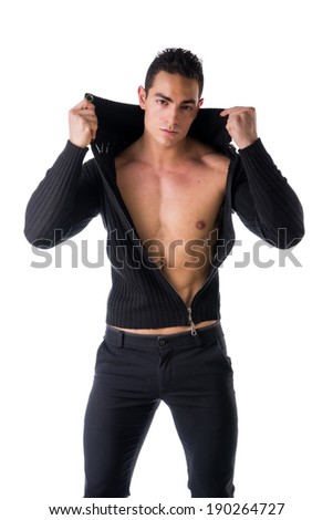 Confident, attractive young man with open sweater on muscular torso, ripped abs and pecs