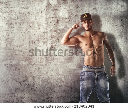 Athletic trendy handsome shirtless  young man in a hat doing a break dance routine