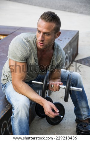 Handsome Hunk Man Lifting Weights Outdoor. Showing Healthy Body While Looking away