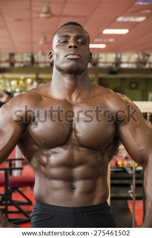 Attractive hunky black male bodybuilder doing bodybuilding pose in gym