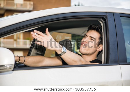 Handsome Angry Young Man Driving a Car and Yelling to someone in front of him