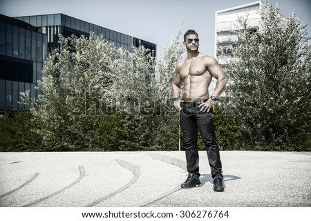 Handsome Muscular Shirtless Hunk Man Outdoor in City Setting. Showing Healthy Body While Looking At Camera