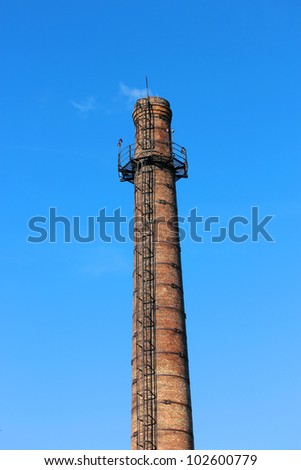 Boiler tube, from which steam escapes, against clear blue sky