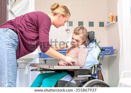 Disability a disabled child in a wheelchair being cared for by a nurse / Disability a disabled child being cared for by a nurse