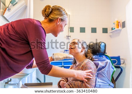 Disability a disabled child being cared for / Disability a disabled child in a wheelchair being cared for with help from a nurse