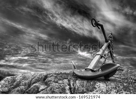 Old anchor at a stormy beach.