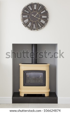 Contemporary yellow wood burning stove with clock in a modern kitchen