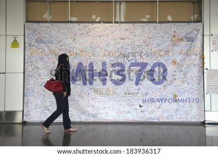 KUALA LUMPUR INTERNATIONAL AIRPORT - MARCH 17: Unidentified Muslim girl poses in front of a banner in support of Malaysia Airlines Boeing 777-200ER MH370 on March 17, 2014 in KLIA, Sepang, Malaysia.