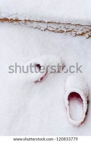 Shoes covered by snow on patio.