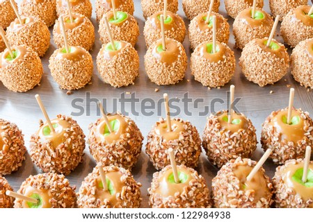 Batch of caramel apples / taffy apples / candy apples  with pecans and peanuts . selective focus.