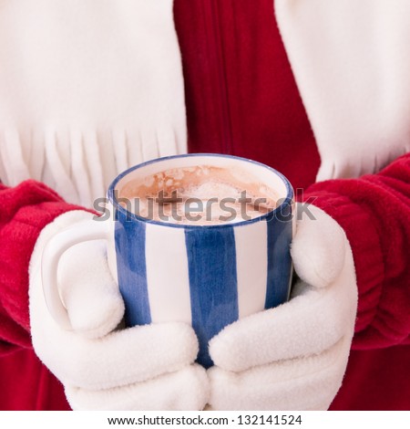 Close up midriff photo of a woman in warm gloves holding cup of hot chocolate with marshmallows at winter. selective focus