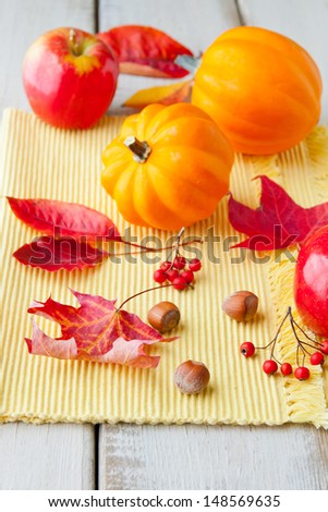 Autumn leaves, nuts, apples, and golden acorn  squash on wood table. selective focus, shallow dof