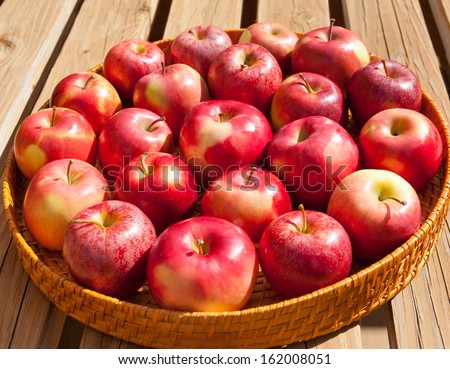 Tray with apples on rustic wooden bench outdoor on sunny day. selective focus, shallow dof