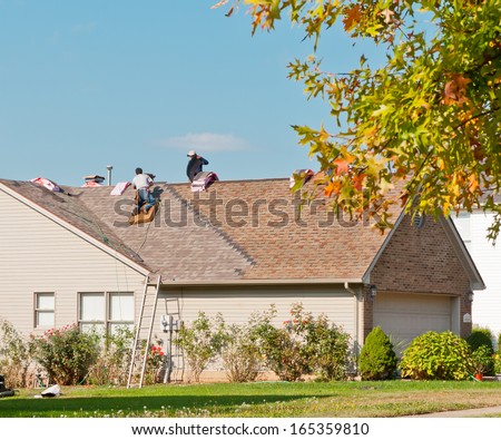 Roofers Repairing The Roof Of A House In The Suburbs.