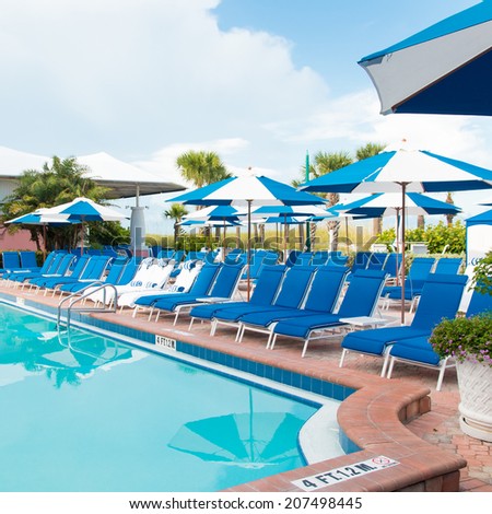 Swimming pool with chaise lounge and umbrellas at tropical resort