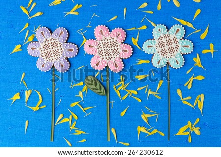 Flowers shaped cookie decorated with ornaments on blue background with yellow flower petals texture