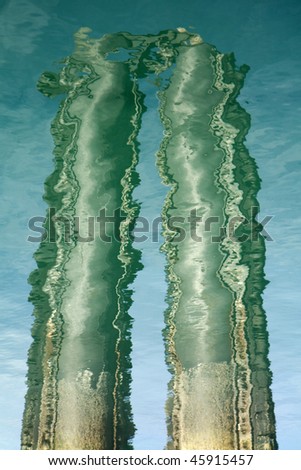 Reflections of masts and poles in the rippled ocean water