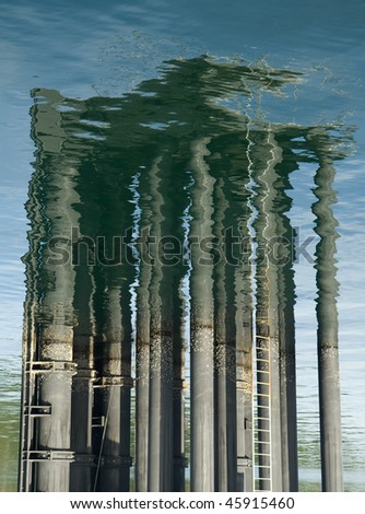 Reflections of masts and poles in the rippled ocean water