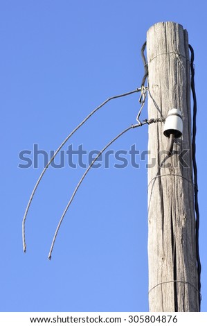 Old wooden post with electric wires cut.