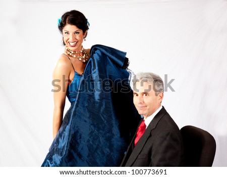 Attractive, mature couple in romantic mood, she is holding her long dress up so he can get a peek underneath.