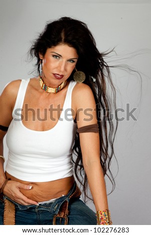 Lovely woman with long dark hair, wearing a undershirt with her hair blowing in the breeze