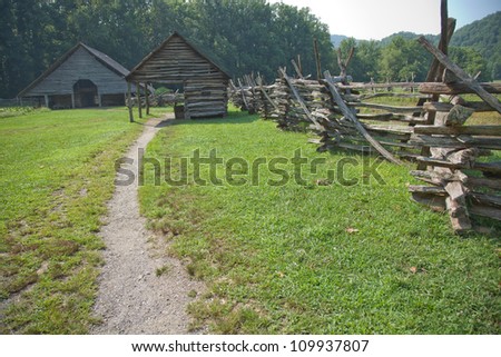 Pathway to a barn by a weathered split rail fence, farm scene