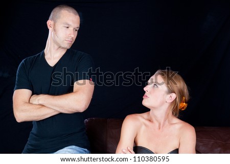 Couple together and angry at each other, he has his arms crossed and they are glaring at each other