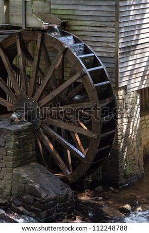 Old wooden, grist mill water wheel, turning with the flow of water