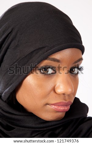 Pretty black, woman wearing a hijab in tradition of a Muslim, looking at the camera with a thoughtful expression
