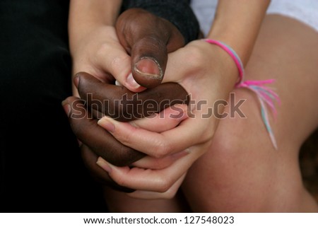 African American black man holding hands with a East Asian, white woman
