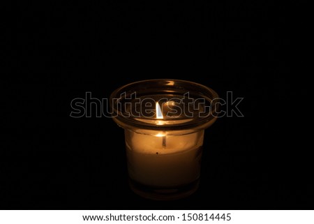 Single candle in a glass jar