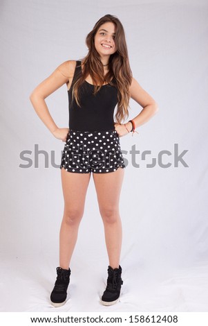 pretty black woman in shorts  sitting on a wooden stool and smiling at the camera