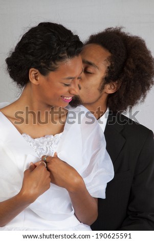 Cute Black couple  he is   behind her and she is kissing her affectionately