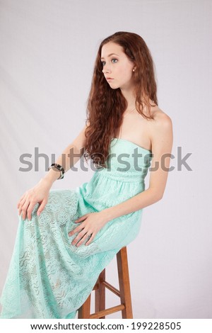 Pretty woman with long hair, sitting and looking left