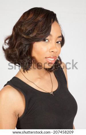 pretty black woman in black tank top, looking at the camera with a serous expression