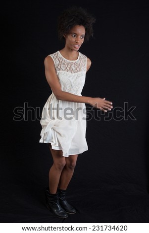 Pretty black woman in a white dress looking at the camera with a smile of pleasure