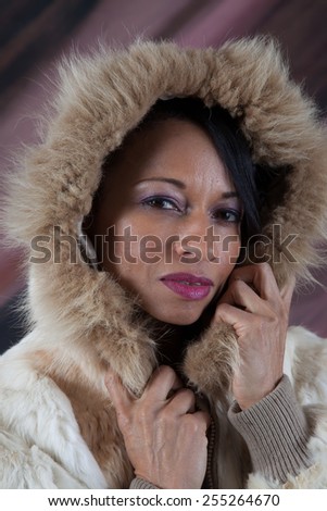 Pretty Black woman in a fur coat with a hood covering her head