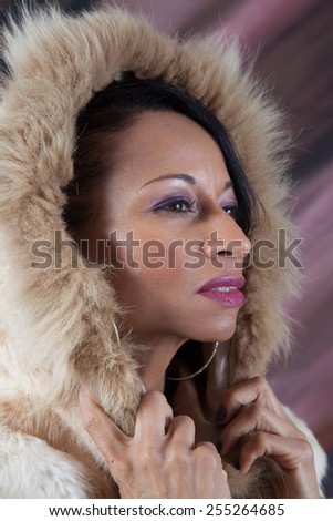 Pretty Black woman in a fur coat with a hood covering her head