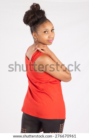 Pretty black woman in blouse looking thoughtfully over her shoulder