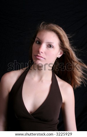 Pretty woman looking left in a black background and black blouse