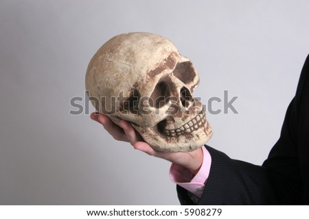 A hand holding a skull