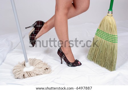 Woman in heels with broom and mop