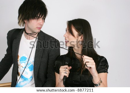 Man with guitar and woman singing with mike cord around his neck