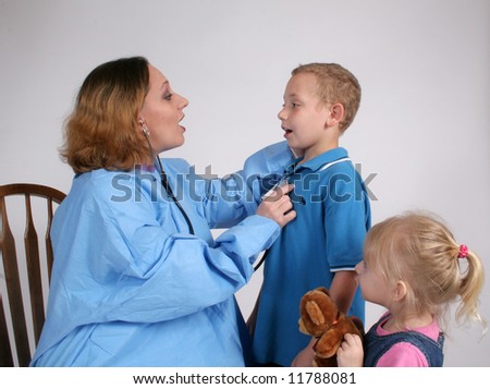 Nurse listening to a boy\'s heart as little sister watches
