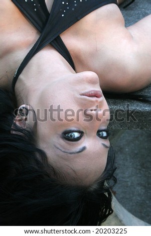 Woman with her head hanging down and looking at the camera