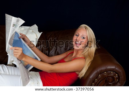 pretty businesswoman reclining with a newspaper
